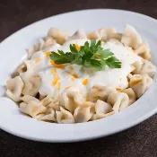 Mantı turco artesanal: mini raviolis cobertos por iogurte cremoso e manteiga de páprica, close perfeito para capturar cores vibrantes.