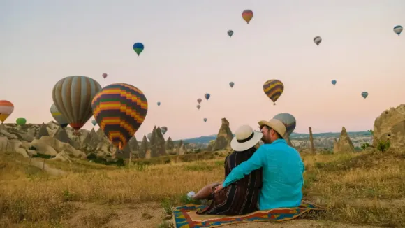 Balões coloridos sobrevoando os vales da Capadócia ao nascer do sol — passeio inesquecível com a Leblon Turismo.