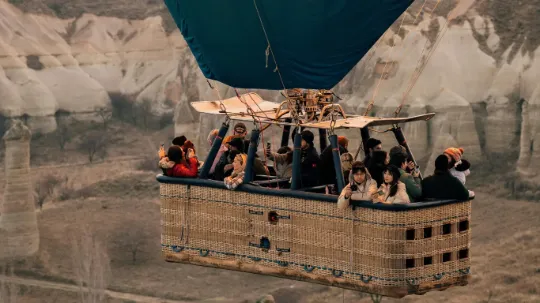 Vista aérea do Vale do Amor na Capadócia com dezenas de balões coloridos — viagem mágica pela Turquia.